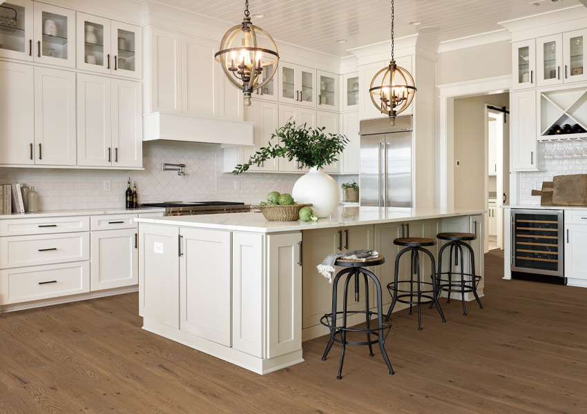 wood flooring in kitchen with white cabinets in beach house