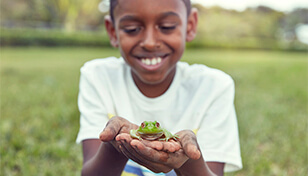 boy holds a frog representing pet-friendly carpet